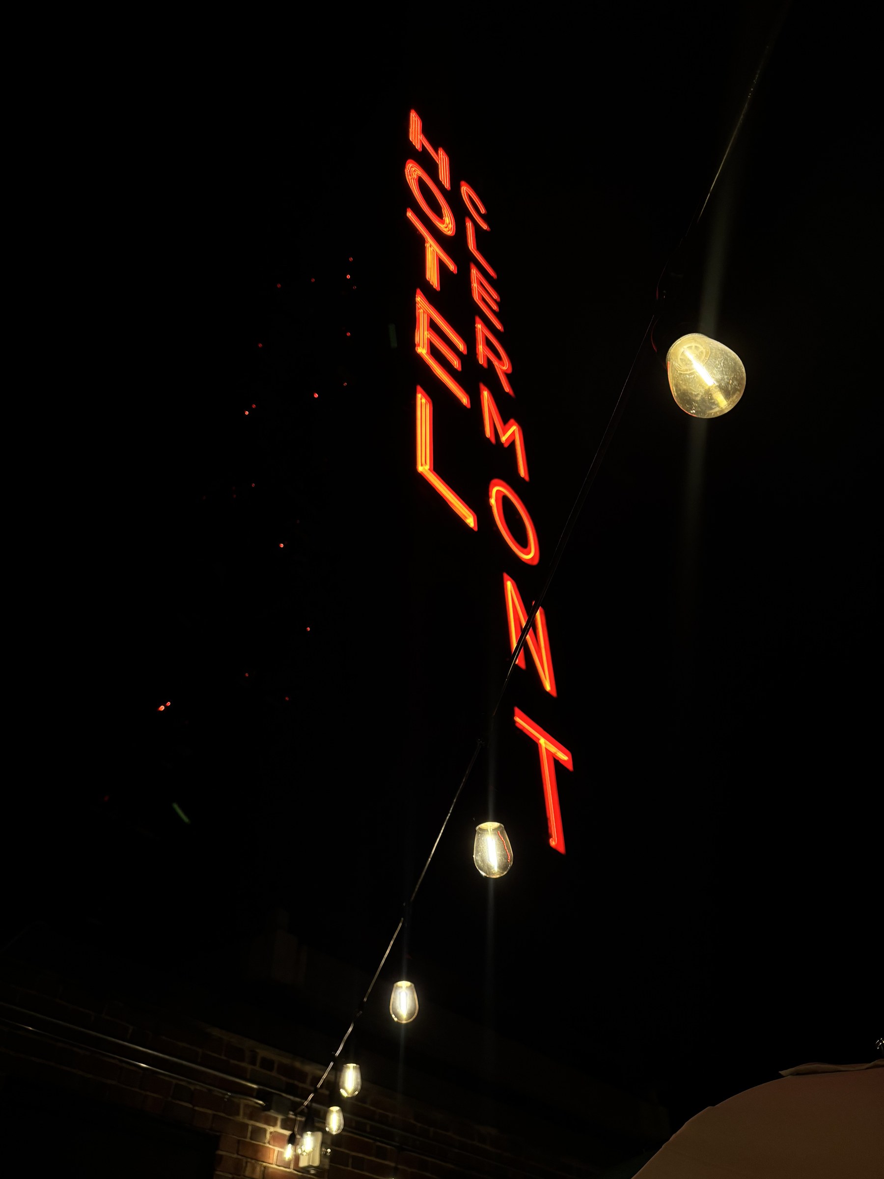 The Hotel Clermont neon sign glowing red against a night sky