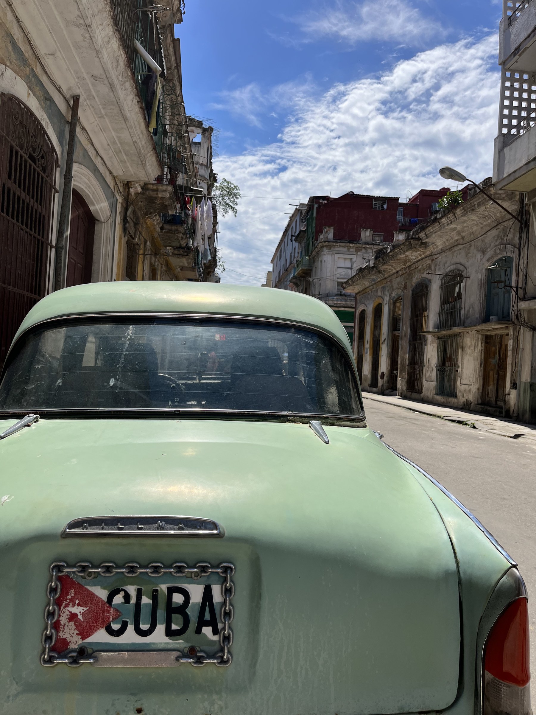 A vintage car on a sunlit street