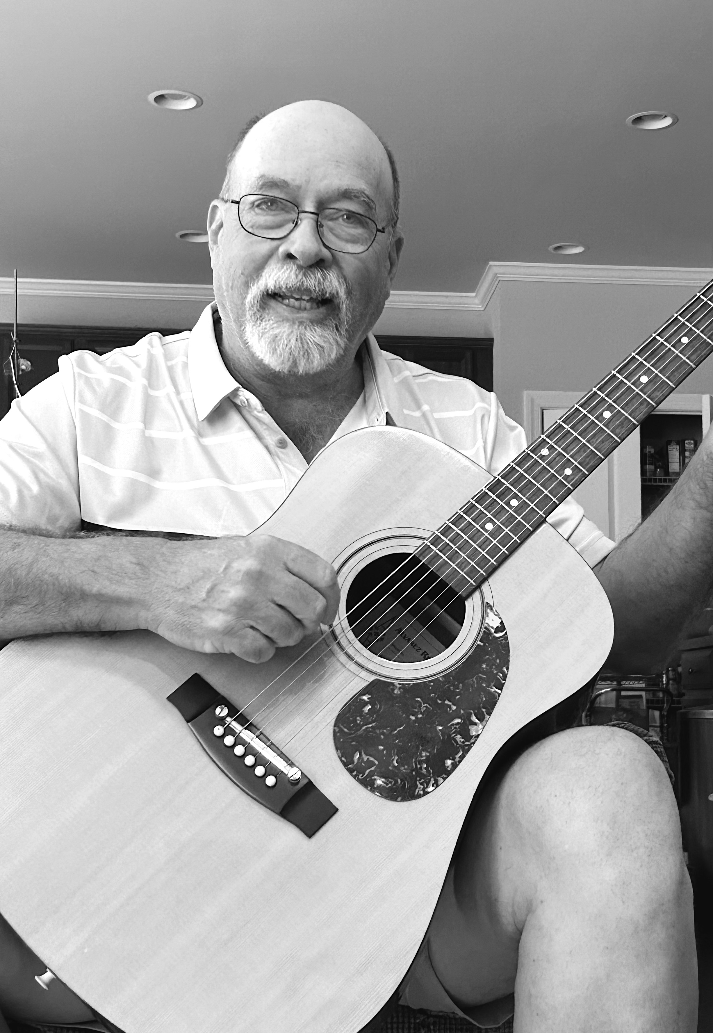 Black and white portrait of a man with an acoustic guitar
